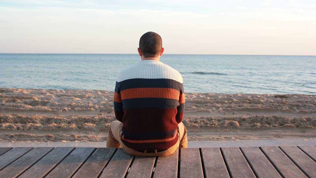 Mann schaut aufs Meer – Symptome und Ursachen von psychischen Erkrankungen Symptome & Ursachen bei Depression, Burnout, Traumafolgestörungen, Schlafstörungen, Angststörungen, Zwangsstörungen und Tinnitus – die Blomenburg Privatklinik klärt auf