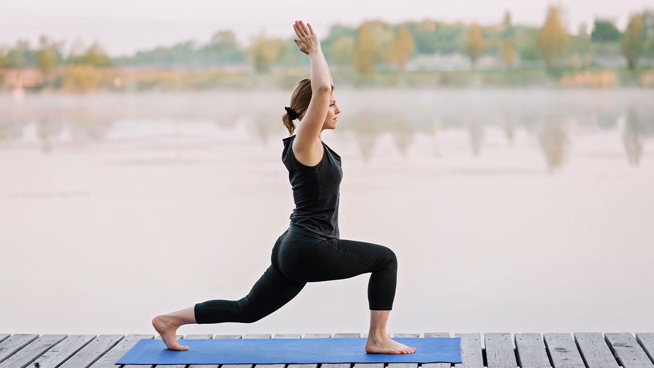 Frau in Yogapose am See Yoga ist Teil unserer Entspannungsverfahren in der Blomenburg Privatklinik