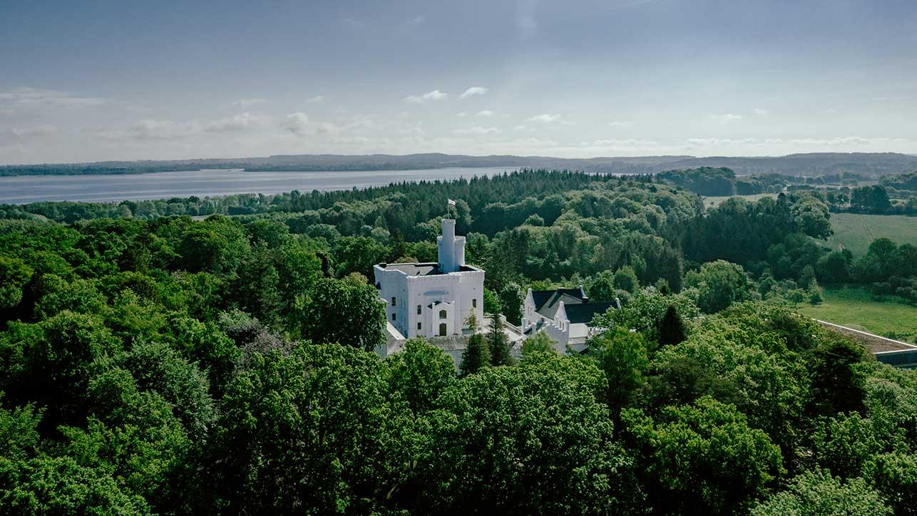 Drohnenaufnahme der Blomenburg Privatklinik mit weitläufiger grüner Umgebung und dem Selenter See Healing Environment in und um die Blomenburg Privatklinik mit Wald, Seen und Wiesen
