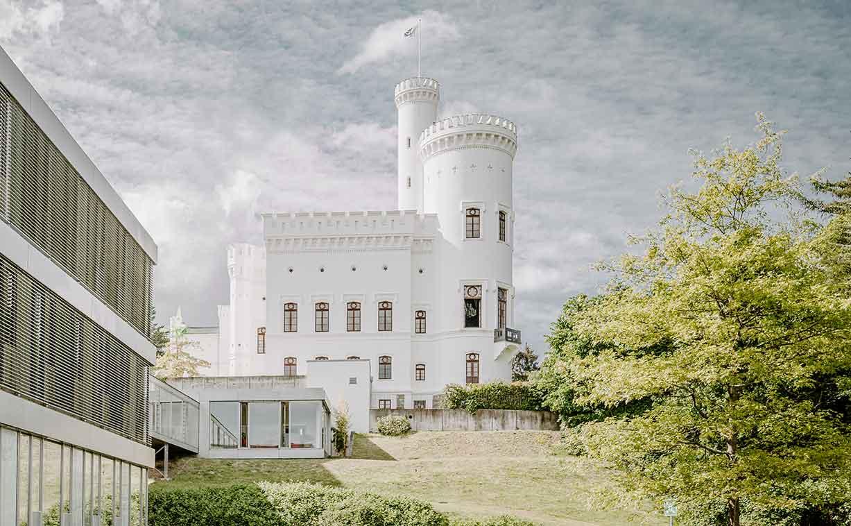Frontalansicht auf das historische Burgareal der Blomenburg Privatklinik Klinikgelände mit historischer Burg und angrenzendem Neubau mit Patientenzimmern der Blomenburg Privatklinik