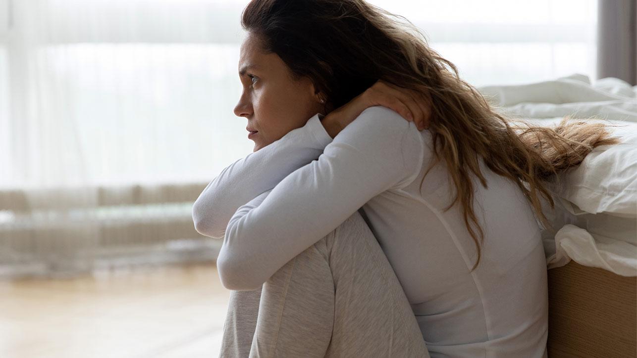 Frau sitzt am Bettende auf dem Boden und leidet unter einer postnatalen Depression Wie Sie eine postnatale / postpartale Depression erkennen, erklärt die Blomenburg Privatklinik.