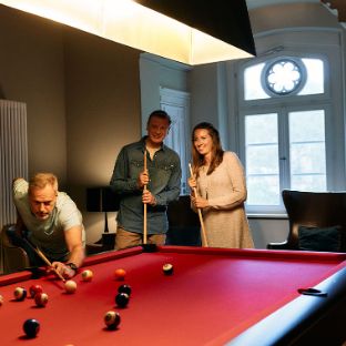 Vier Patient:innen spielen Billiard in gemütlichen Raum