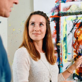 Junge Frau präsentiert ihr abstraktes Kunstwerk