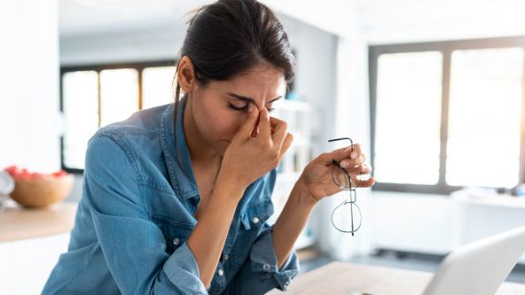 Angst vor der Arbeit - Burnout Eine junge Dame sitzt gestresst am Rechner.
