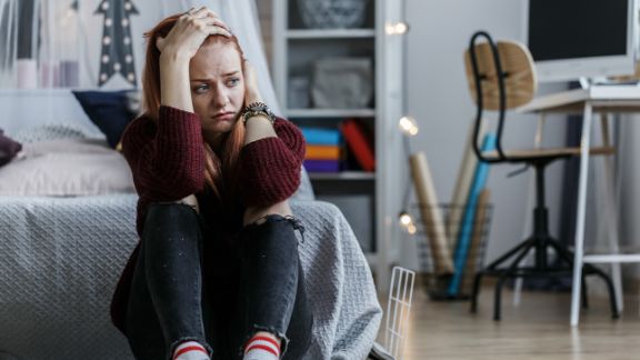 Unterschied zwischen Schulverweigerer und Schule schwänzen Teenager sitzt weinen im Zimmer