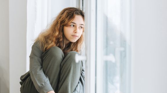 Vermeidungsreaktion bei Schulangst Junges Mädchen schaut besorgt aus dem Fenster