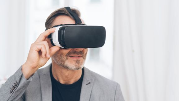 Mann im grauen Anzug mit VR-Brille