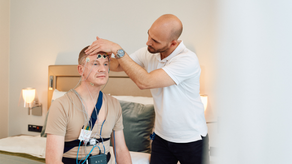 Therapeut platziert Elektroden an der Stirn eines Patienten