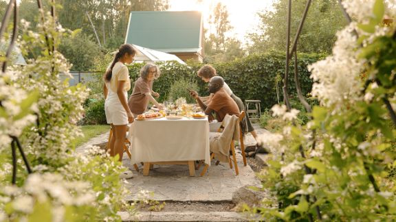 Sommerdepression: Angehörige und Gesellschaft Gruppe Leute isst in einem Garten zu Abend.