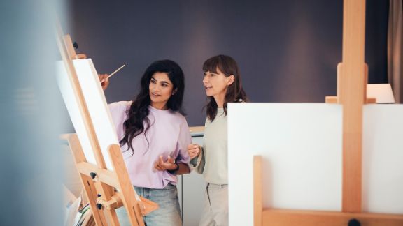 Patientin in der Kunsttherapie Patientin malt an Staffelei in der Kunsttherapie