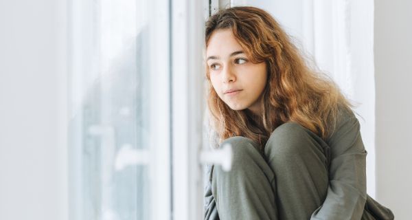 Kinder- und Jugendambulanz Frankfurt Teenagerin schaut aus dem Fenster