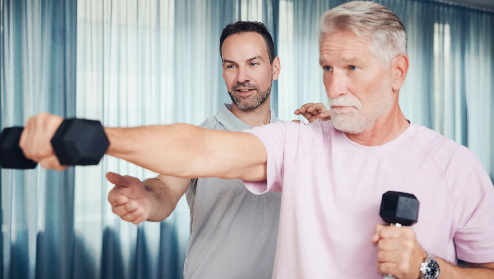 Therapeut unterstützt Patient in der Sporttherapie