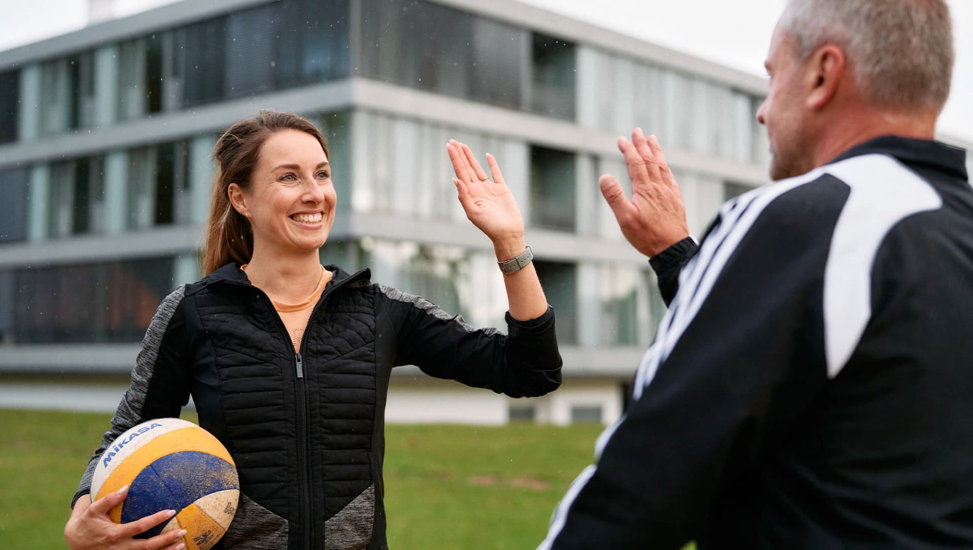 Patientin und Patient geben sich beim Volleyballspielen ein High Five