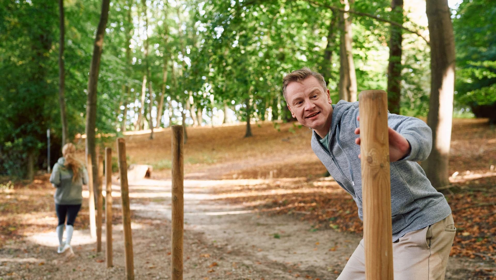 Patientin und Patient laufen im Salon um Holzstäbe im Wald