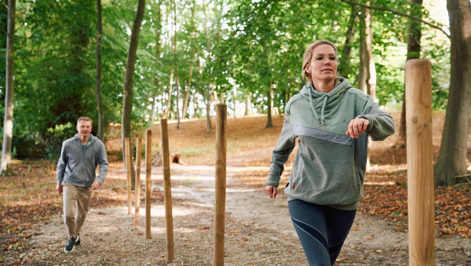 Patientin und Patient laufen im Salon um Holzstäbe im Wald