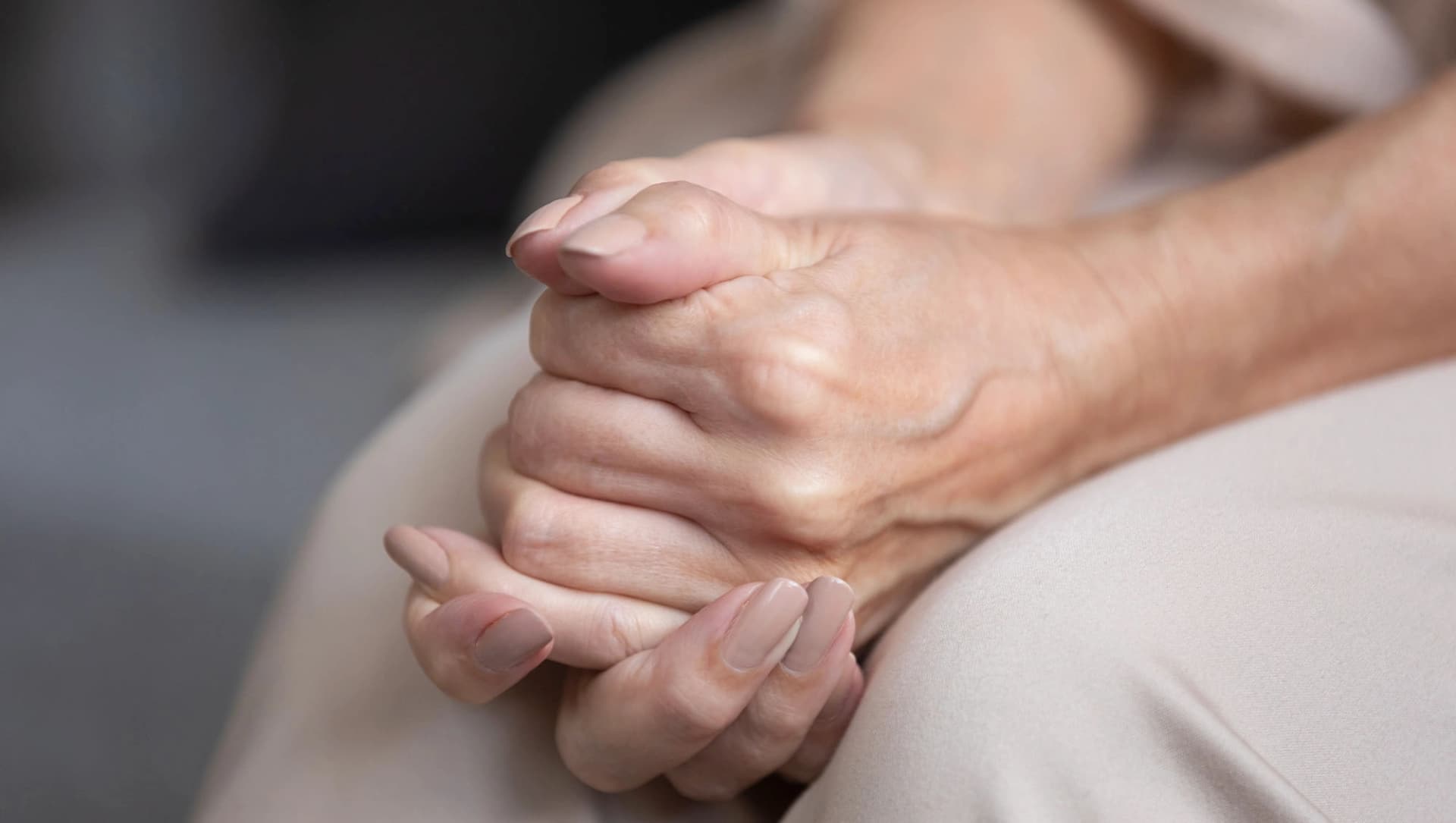 Ältere Dame ringt angespannt mit den Händen