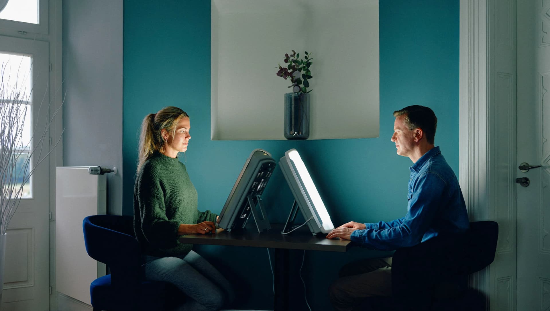 Patienten sitzen mit geschlossenen Augen vor Sonnenlicht-Lampe