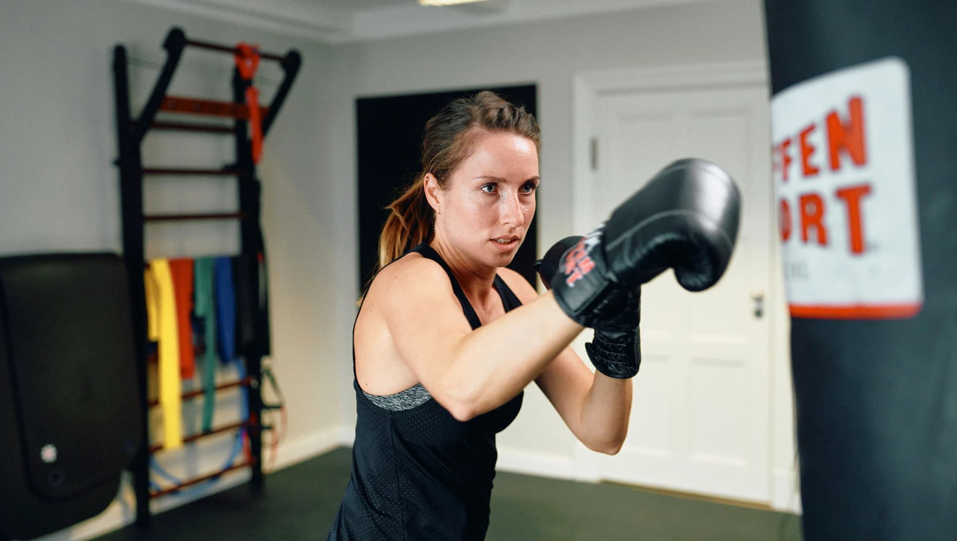 Patientin beim therapeutischen Boxen mit Boxsack